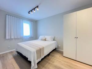 圣劳伦斯海滨Riviera | Excelente Novo com Enxoval Completo的一间带床和窗户的白色卧室 更多59张照片