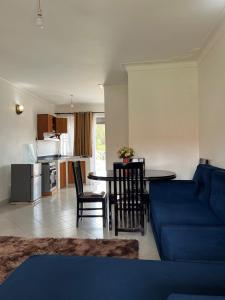a living room with a blue couch and a table at Ashok Apartments APT C in Buzzi