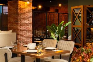 ein Holztisch in einem Restaurant mit Stühlen und einer Tisch- und Stuhlplatte in der Unterkunft Krystal Resort Apartment A108 in Bakuriani