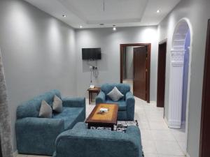 un salon avec deux canapés bleus et une table dans l'établissement تميز الحمدانية Tamayoz Al-Hamdaneyah, à Djeddah