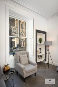 a living room with a chair and a window at 2Bedroom apartment by the castle in Edinburgh