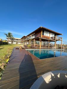 a resort with a swimming pool and a building at Kamaiurá Pousada in Caraíva