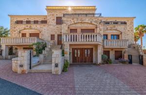 a large stone house with a staircase in front of it at SeaStone Villa in Hersonissos