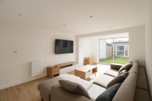un salon avec un canapé et une télévision dans l'établissement Coliving Henri Barbusse - salle de sport - chambres avec SDB privative, au Mans 13 autres photos