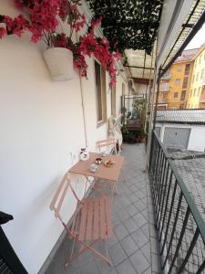 d'une table et d'une chaise sur un balcon fleuri dans l'établissement Casa Grace Relax nel cuore del Monferrato, à Casale Monferrato