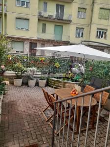 une table et des chaises avec un parasol sur une terrasse dans l'établissement Casa Grace Relax nel cuore del Monferrato, à Casale Monferrato