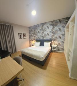 a bedroom with a bed and a table and a desk at Je T'aime Solar São João in São João da Madeira