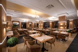a restaurant with tables and chairs in a room at Hotel Gabriela in Vişeu de Sus