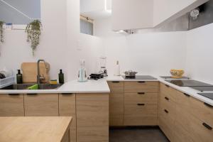 - une cuisine avec des murs blancs et des placards en bois dans l'établissement Je T'aime Solar São João, à São João da Madeira 93 autres photos