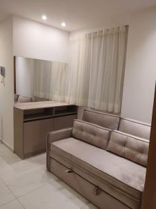 a living room with a couch and a mirror at Porto City - Flat 06 com Jacuzzi in Porto De Galinhas +13 photos