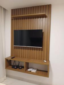 a flat screen tv on a wooden wall at Porto City - Flat 06 com Jacuzzi in Porto De Galinhas