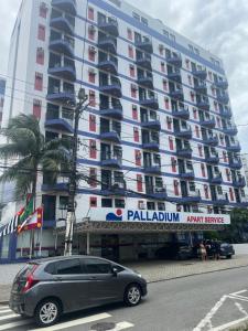 a car parked in front of a large building at Flat Palladium in São Vicente