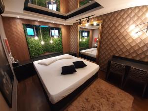 une chambre avec un grand lit et un miroir dans l'établissement Hotel Motel Paradiso - Cruz Alta-RS, à Cruz Alta