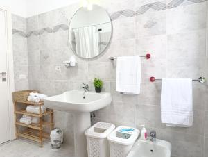 Un baño con lavabo, espejo e inodoro. en Pignola Maison, en Pignola 70 fotos más