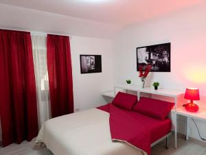 Un dormitorio con una cama con cortinas rojas y un escritorio. en Pignola Maison, en Pignola