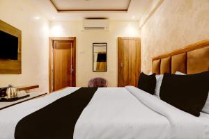 a bedroom with a large white bed and a desk at Hotel O Gangay in Prayagraj +18 photos