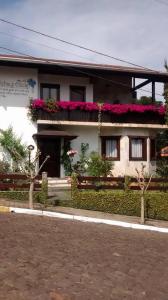 a house with flowers on the side of it at Hospedaria Gãstehaus Enzian in Treze Tílias