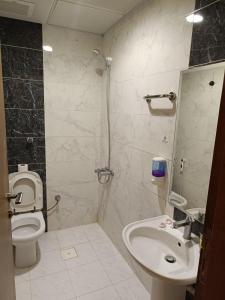 un baño con inodoro y lavabo en فندق مناير الاصول, en Al Khansāk