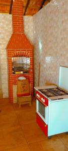 een keuken met een fornuis en een bakstenen oven bij cachoeira do nono in Socorro