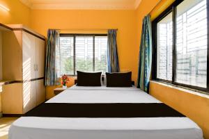 a bedroom with a large bed in front of a window at Hotel O by OYO Love Rooms in Pānchuria