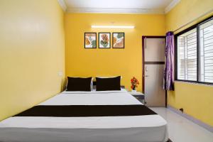 a bedroom with a large bed with yellow walls at Hotel O by OYO Love Rooms in Pānchuria +61 photos