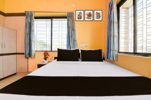 a large bed in a room with windows at Hotel O by OYO Love Rooms in Pānchuria