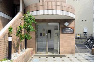 an entrance to a building with a revolving door at MIYAVI#407 3min walk Narimasu Station, 3 people, double bed & sofa, Tokyo's largest Don Quijote in Tokyo