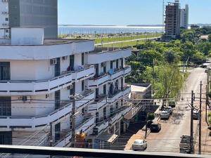 a building with white balconies on a city street at Full Encarnacion House in Encarnación