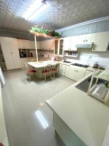 a large white kitchen with a table and chairs at Full Encarnacion House in Encarnación