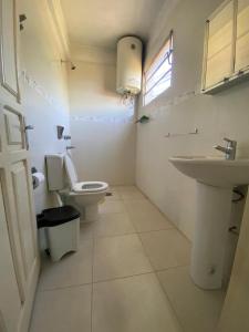 a white bathroom with a toilet and a sink at Full Encarnacion House in Encarnación