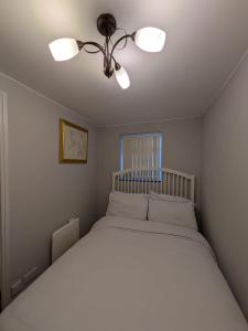 NeepsendBright Comfortable 1 Bedroom Flat的卧室配有白色的床和吊扇 更多11张照片