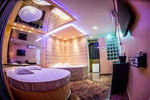 Cette chambre comprend un lit et une baignoire. dans l'établissement Hotel Motel Paradiso - Cruz Alta-RS, à Cruz Alta