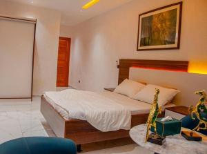 Un dormitorio con una cama y una sala de estar. en Villa Complexe Luxueux Saly-Malikunda, en Saly Portudal