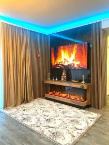 une cheminée dans un salon avec un feu dans l'établissement Fabulous Views Silver Mountain 3 Rooms Apartment, à Poiana Brasov
