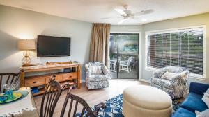 a living room with a flat screen tv and chairs at Kingston Plantation - Laurel Court #112 - Seaclusion in Myrtle Beach