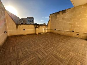 萨奈特Spacious Bright Apt With billiard Table and Terrace的一间空房间,铺有木地板,设有砖墙