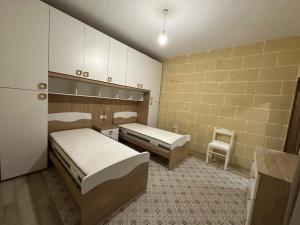 萨奈特Spacious Bright Apt With billiard Table and Terrace的有两张床和一把椅子的房间