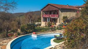 a house with a swimming pool in front of a house at Le Logis du Rocher in Saint-Marcet