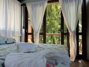 a bedroom with a bed in front of a window at Casa Saíra in Bombinhas
