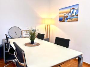Una mesa de comedor con sillas y un reloj en la pared. en Hellenic Pleasure Residences, en Atenas