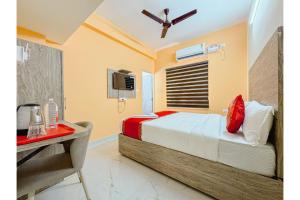 Un dormitorio con cama, escritorio y televisión. en Redfox Service Apartment DLF, en Chennai