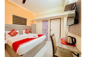 Un dormitorio con una cama y un escritorio con televisión. en Redfox Service Apartment DLF, en Chennai
