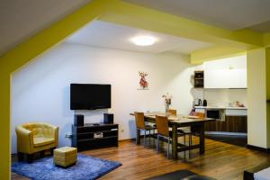 a living room with a dining room table and a kitchen at Apartmán 44 in Donovaly