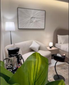 un soggiorno con un divano e una grande pianta verde di استديو لوفينا 2 a Riyad