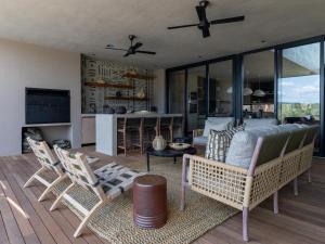 Izakithi River Villa في ماليلين: غرفة معيشة مع أريكة وكراسي على السطح