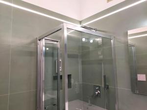 Un baño con ducha con puerta de cristal en Dimora Tulliano, en Manfredonia