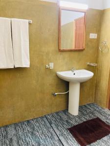 a bathroom with a sink and a mirror and towels at Wild Safari River Cottage Udawalawa in Udawalawe