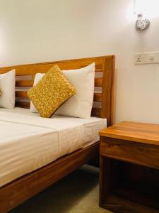 a bed with a wooden headboard and a yellow pillow at Wild Safari River Cottage Udawalawa in Udawalawe