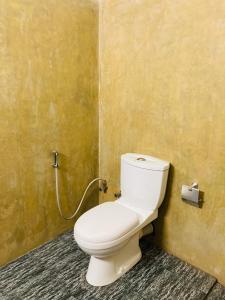a bathroom with a white toilet in a room at Wild Safari River Cottage Udawalawa in Udawalawe +3 photos