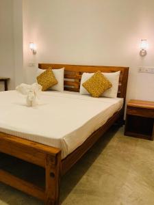 a bedroom with a large bed with pillows on it at Wild Safari River Cottage Udawalawa in Udawalawe